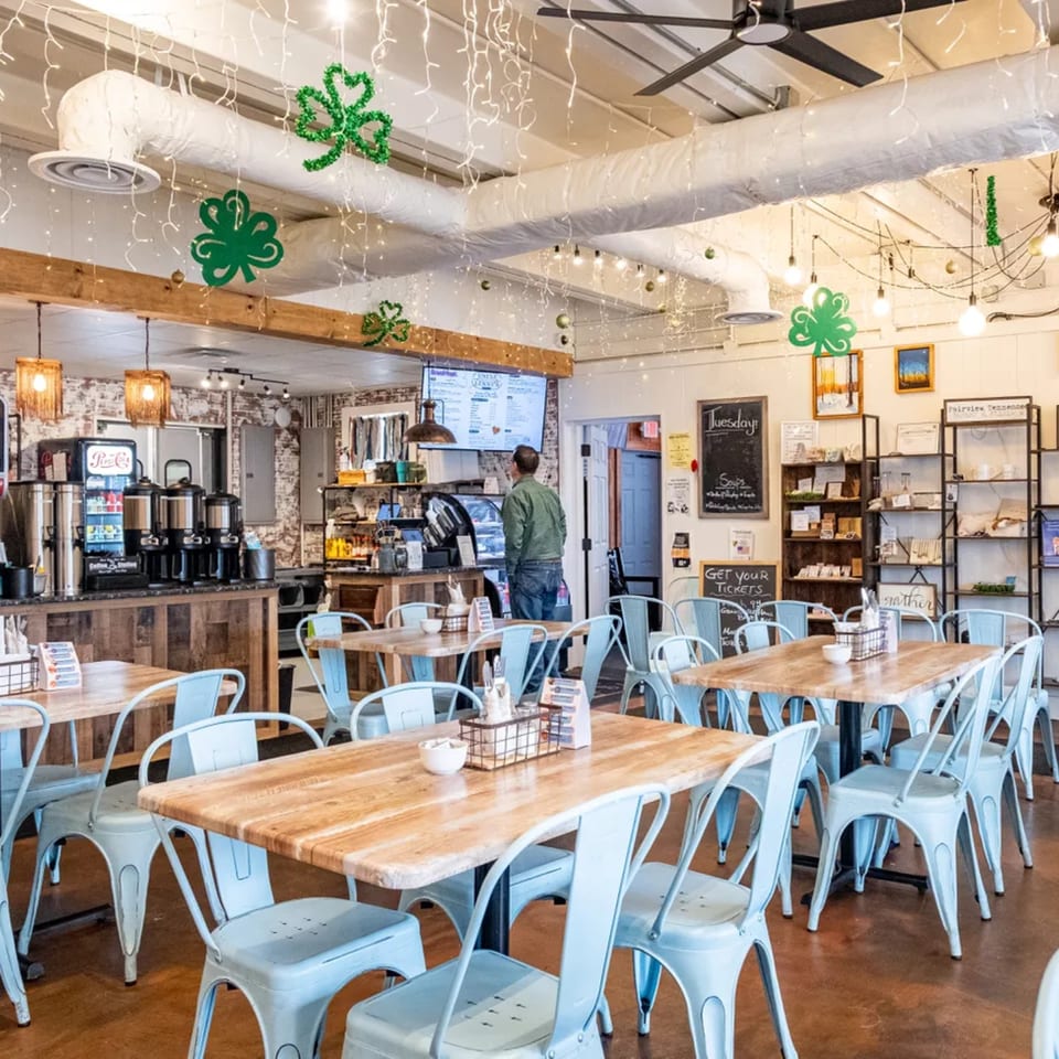 The interior of Uncle Lenny's Country Cafe, featuring light blue chairs, wooden tables, and St. Patrick's Day decorations.